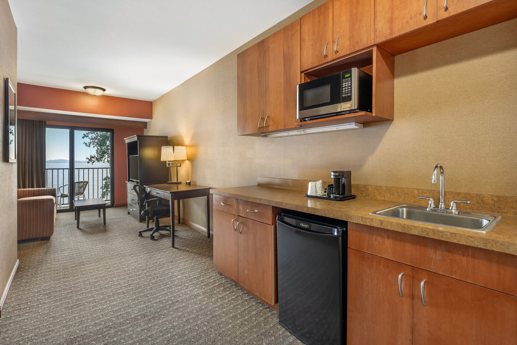 a kitchen with a microwave and a desk